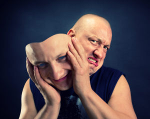 Man taking off his happy facial mask